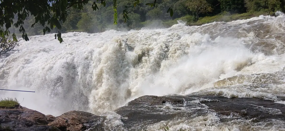 Der Nil schießt weiß über die felsige Kante des Wasserfalls